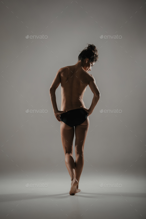 Graceful naked woman in sensual pose in studio - Stock Photo