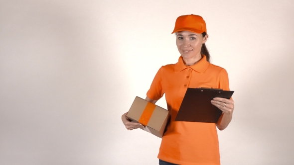 Beautiful Female Courier In Orange Uniform Delivering a Parcel. Light Gray Backround alt