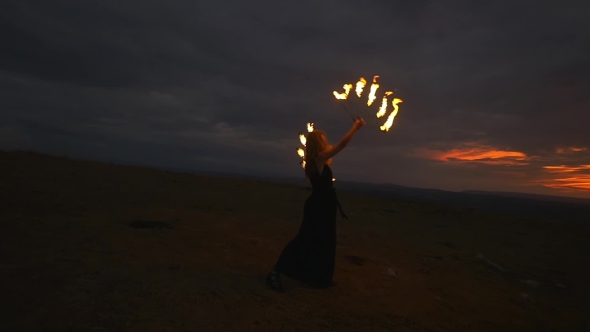 Woman With Burning Torches At The Top Of The Hill