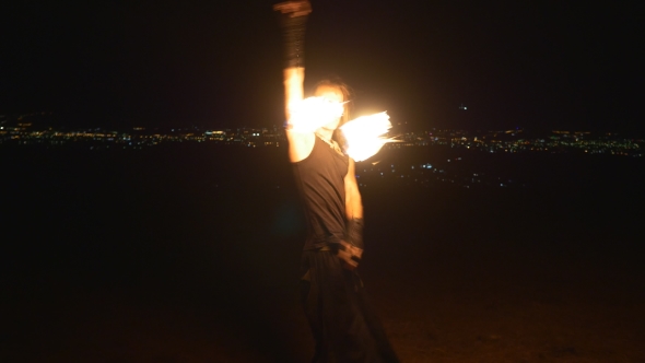 Man Turns Fire Poi In Front Of City Lights