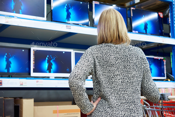 Woman looks at LCD TVs in shop