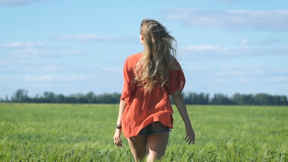 beautiful-blonde-young-romantic-woman-in-a-red-shirt-walking-slowly-at