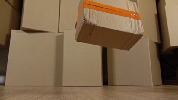 Damaged Parcel Falling Down On The Floor. Brown Cartons Background. Flaw And Unprofessional Work alt