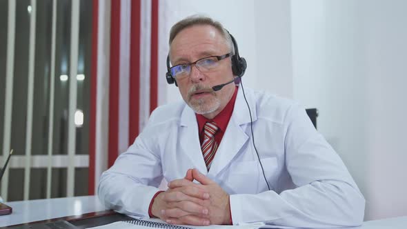 Serious doctor giving audio consultation call.  alt