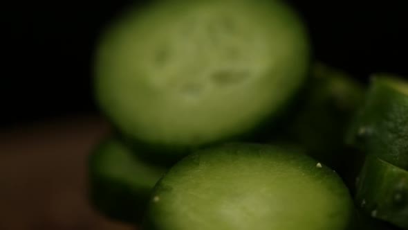 Sliced Cucumbers In A Plate Rotate On A Black Background