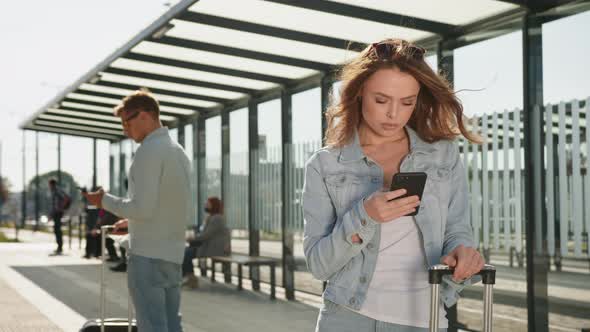 A Young Woman is Texting on Her Smartphone alt