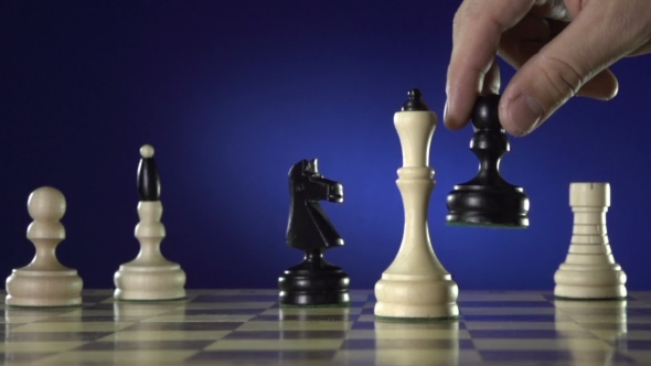 Black Chess Player Knocks Down the White King With His Piece