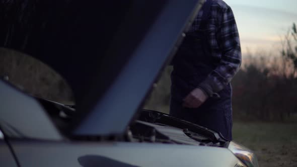 Mechanic in Uniform Open Hood Motor and Fixing Broken Car on Road