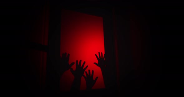 Hands creep up on a glass door