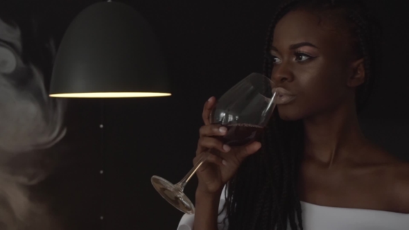 Young Beautiful African American Female Fashion Model Holding Wineglass In Her Hand And Drink From