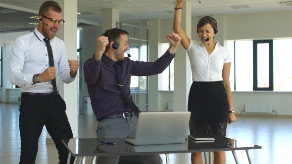 Group Of Happy Business People In Smart Casual Wear Looking At The Laptop And Gesturing
