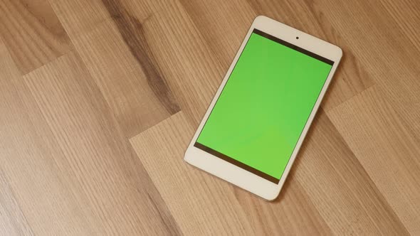 On the floor chroma key greenscreen modern tablet display 4K 2160p 30fps UHD tilting video - Slow ti alt