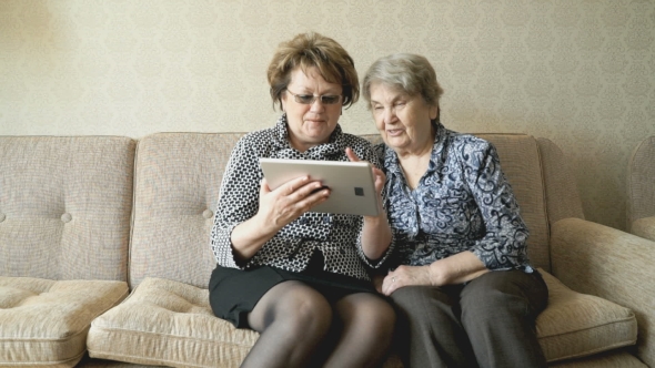 The Old Woman And Her Friend Looking At Photos