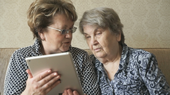 Two Women Watching Photos on a Digital Tablet