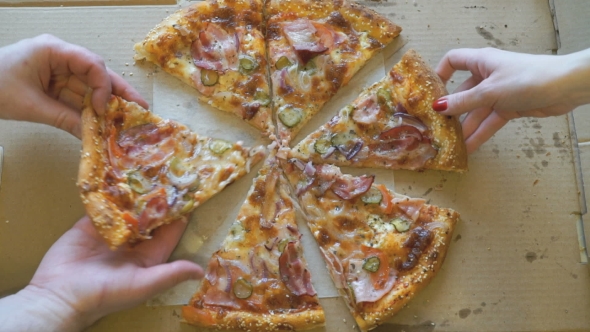 Hands Taking Pieces Of Pizza From a Cardboard Box