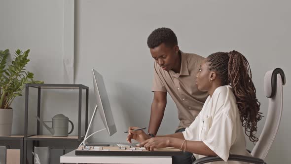 Coworkers Making Task List on Corkboard alt