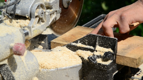 Man Sawing Wooden Plank With Circular Saw