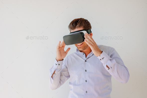 Happy businessman watches content on a virtual reality display - Stock Photo - Images