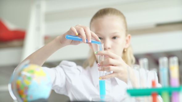 School-age Girl Pours Blue Liquid From The Flask. Chemistry Experiment