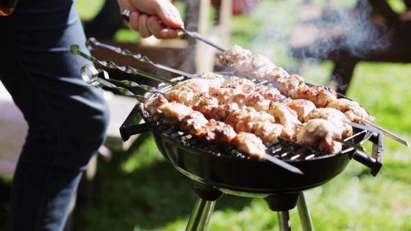 Man Cooking Meat On Barbecue Grill At Summer Party alt