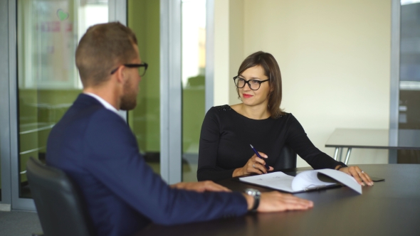 Business Meeting In Office Two Business People Discussing Contract alt