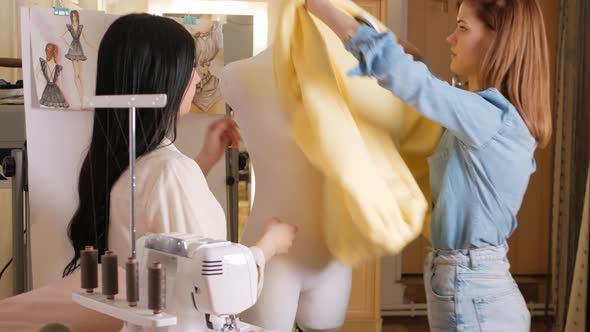 Women Seamstresses Apply Yellow Jacket to Model Mannequin