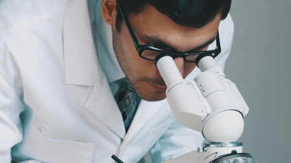 Young Scientist Looking Through The Microscope