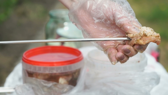 Hand Is Stringing Pieces Of Raw Meat On a Skewer