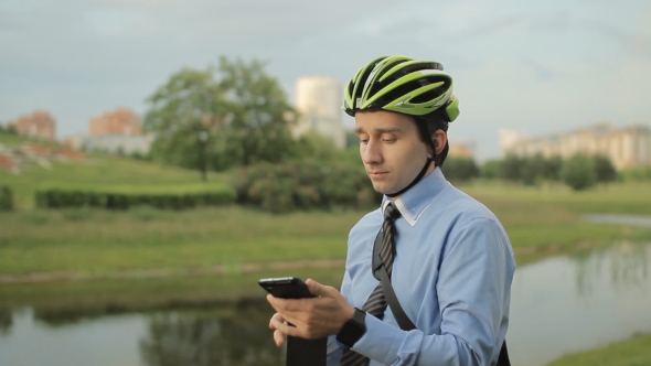 Businessman On Folding Bicycle With Smartphone