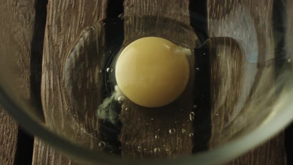 Slow motion of egg yolk falling in bowl alt