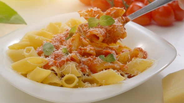 Hot Pasta With Tomato Sauce, Parmesan Cheese And Basil On a Spoon