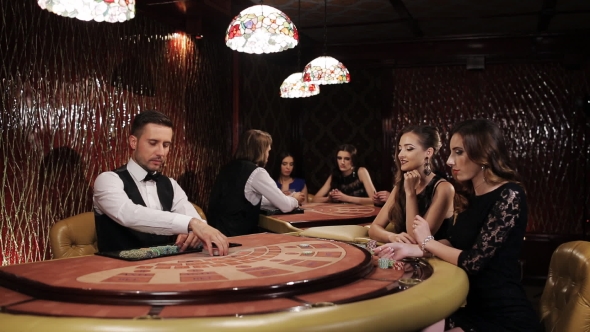 Two Beautiful Women Playing At The Table Blackjack In a Casino alt