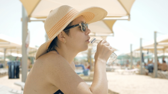 A Thirsty Female Is Drinking Water At The Beach