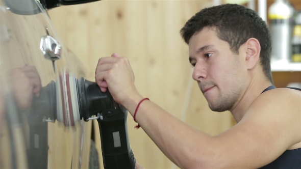 The Worker Polishes a Car Cowl With The Electric Tool. Car Detailing Series.