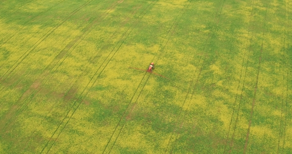 Aerial View Of Tractor Spraying Canola Field alt