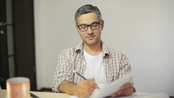 Creative Designer Sketches with Pencil on a Sheet of Paper