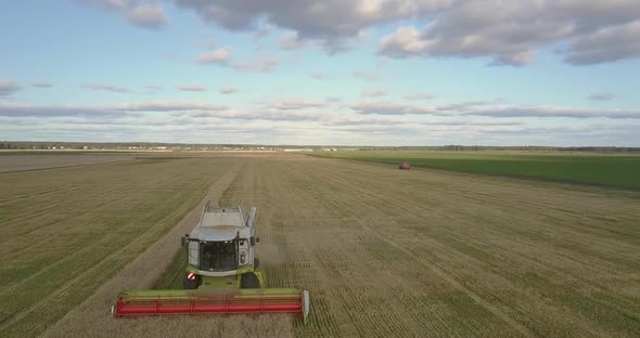 Aerial Motion Over Operating Thresher at Peak of Harvesting alt