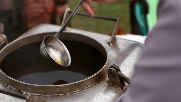 A Woman Pours a Ladle Compote into a Glass alt