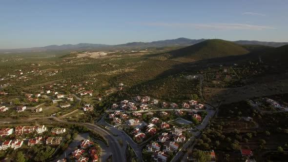 Flying Over the Town and Green Landscape with Hills. Trikorfo Beach, Greece alt