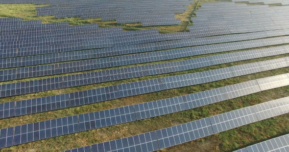 Aerial View. Flying Over The Solar Power Plant With Sun. Solar Panels And Sun. Aerial Drone Shot