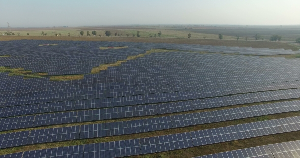 Aerial View. Flying Over The Solar Power Plant With Sun. Solar Panels And Sun. Aerial Drone Shot