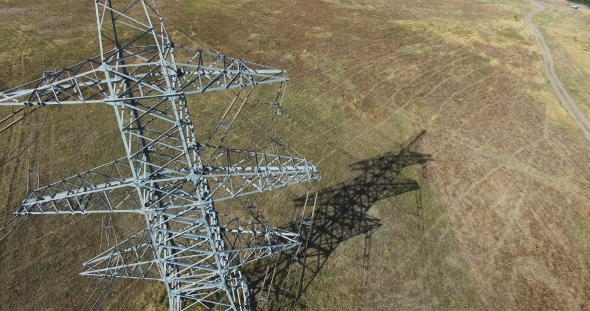AERIAL: Flying Up The High Voltage Electricity Tower And Power Lines. Aerial Drone Shot.  30Fps