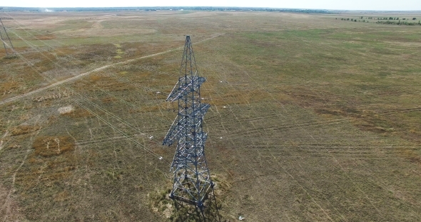 AERIAL: Flying Up The High Voltage Electricity Tower And Power Lines. Aerial Drone Shot.  30Fps