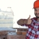 Male Builder Corrects His Hard Hat At The Building Under Construction - VideoHive Item for Sale