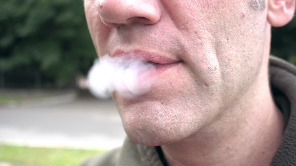 Man Exhaling E-cigarette Smoke Cloud From Mouth