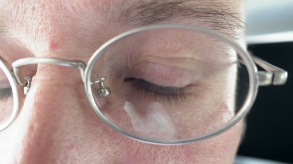 Person's Brown Eye Through The Metal Glasses