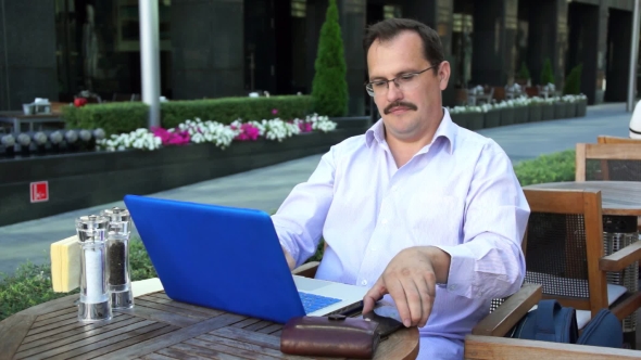 Middle Age Businessman Works On Laptop