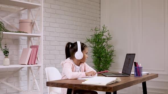 Little Child Girl Using Laptop Computer for Studying Online E-learning System.