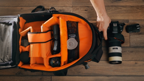 Photographe Pack His Camera and Lenses to Bagpack.  alt