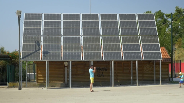 Father Take Picture Of Running Son Along House With Solar Panels On Rooftop Piraeus, Greece alt